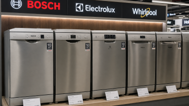 Ряд сріблястих посудомийних машин трьох брендів — Bosch, Electrolux та Whirlpool — на торговому стенді з цінниками в магазині побутової техніки